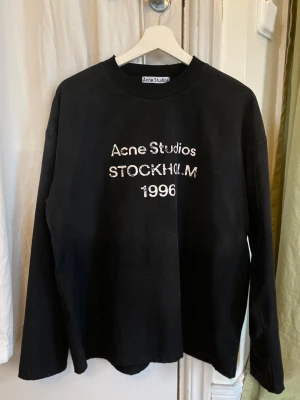 Svart sweatshirt Acne Studios - Cool svart sweatshirt från Acne Studios med text på bröstet. Supersnygg och perfekt nu till våren! Har endast använt den några gången och den är i väldigt bra skick! Oversized fit🥰
