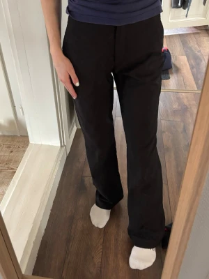 Svarta kostymbyxor  - Säljer ett par svarta bootcut byxor med hög midja. Byxorna har en klassisk passform och är perfekta för dig som gillar en stilren look. Oanvända i storlek S, HM. Jag är 163 cm lång. 