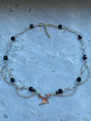 Halsband med berlock - Handgjort halsband med pärlor, kedjor och silverfärgad berlock💕