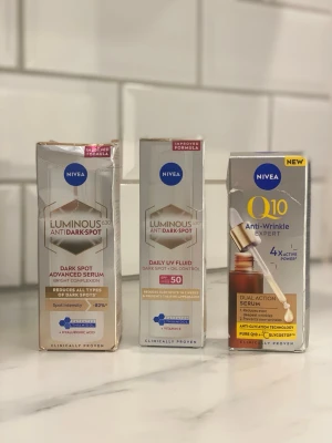 Nivea serum och UV-fluid set - Tre olika produkter från Nivea: Luminous630 Anti Dark-Spot Advanced Serum, Luminous630 Anti Dark-Spot Daily UV Fluid SPF 50 och Q10 Anti-Wrinkle Expert Dual Action Serum. Förpackningarna är i guld, vitt och blått. Perfekt för dig som vill jobba mot pigmentfläckar och rynkor.
