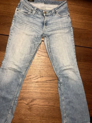 Bootcut jeans  - Säljer ett par ljusblå bootcut jeans med klassisk femficksdesign och dragkedja med knapp. Jeansen har en snygg tvättad look och raka ben som går ut lite nedtill. Perfekta till sneakers eller boots. Jättesnygg 90-tals jeans som är moderna idag! Säljer då dom är för stora för mig. Storleken är mellan en M och L. 