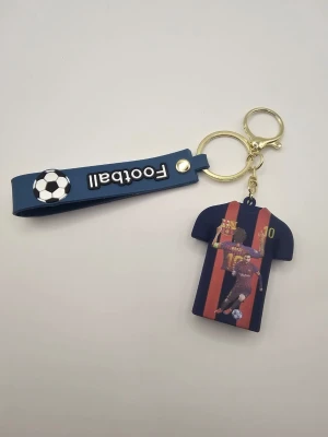 Nyckelring Messi tröja och fotboll - Säljer en cool nyckelring med blått band där det står 'Football' och en liten fotboll. Hängande är en tröja i blått och rött med Messi och nummer 10 tryckt på båda sidor. Perfekt för dig som älskar fotboll och Messi.