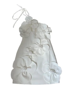 Vit kort klänning med stora blommor - Supersnygg vit kort klänning med stora 3D-blommor framtill och axelbandslös design med knyt i höger axel. Klänningen har en unik och trendig look som verkligen sticker ut. Perfekt för dig som vill ha något extra till sommaren eller studenten!