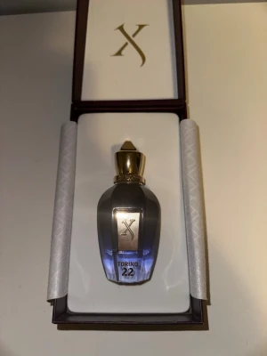 Xerjoff Torino 22 parfym - Lyxig parfym från Xerjoff i modellen Torino 22. Flaskan är djupblå med gulddetaljer och har en elegant, exklusiv design. Kommer i en snygg presentförpackning med guldfärgad logga på locket. Perfekt för dig som gillar exklusiva dofter och snygg design.