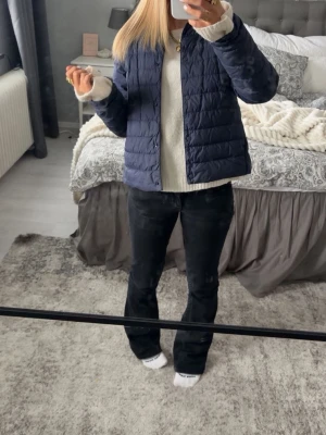 Mörkblå uniqlo jacka - Snygg mörkblå pufferjacka i kortare modell med quiltat mönster. Jackan har dragkedja framtill och en enkel, stilren design utan synliga loggor. Perfekt för kalla dagar och lätt att matcha med olika outfits.