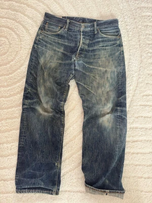 Oni Selvedge Denim - Snygga selvedge jeans från det japanska märket Oni, bra kvalitet på materialet och rätt så tunga jeans. Size tagged W34 men midje måttet är 43 cm tvärs över, inga flaws, dm för mer info Mått: W 43 cm L 98 cm Benöppning 22 cm