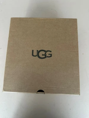 Svarta UGGS LOWMEL boots med foder  - Säljer ett par svarta UGG boots med mjukt och varmt foder. Skorna har en klassisk design med snörning och fluffig kant upptill. Perfekta för kalla dagar och riktigt sköna att ha på sig. Levereras i originalkartong.