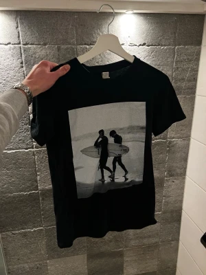 Svart t-shirt med surf-tryck från Desure - Tja säljer denna tvärfeta tishan med snyggt tryck då den ej kommer till användning numera! Inga defekter. Passar storlek XS - S! Kan såklart gå ner i pris så skicka vid frågor och/eller funderingar mvh ville✨