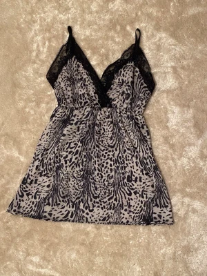 Leopard topp - Säljer ett jättefint leopard linne/nattlinne (/tunika då den är lite lång, se bild av mått)💗🐆Den har svarta spetsdetaljer vid urringningen och tunna axelband. Skriv om du har frågor!