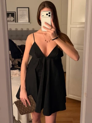 Svart kort klänning med smala axelband - En svart kort klänning med smala axelband och v-ringning. Super snyggg men tyvärr för liten som man kan se :/