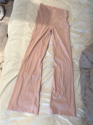 Ljusrosa utsvängda träningsbyxor  - Säljer ett par ljusrosa träningsbyxor med utsvängda ben. Är från lager 157 i storlek 160. Endast provade 