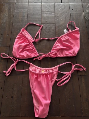 Rosa bikini med knyt - Snygg rosa bikini med knytning fram till! Endast testad men säljer pga att den inte passade mig! Storlek topp - M, storlek underdel - S