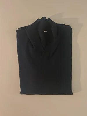 Mörkblå piké t-shirt med krage 158-164 - Snygg mörkblå piké t-shirt med klassisk krage och korta ärmar. Perfekt för en clean och stilren look. Tillverkad i mjuk bomull som känns skön mot huden. Enkel att matcha med jeans eller shorts. Size: 158-164cm