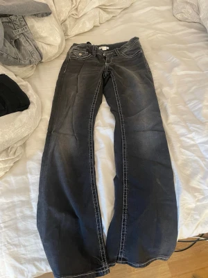 Svarta bootcut jeans med kontrastsömmar - Säljer ett par svarta bootcut jeans med vita kontrastsömmar, Jeansen har låg midja. Jag har använt dem 1 gång, säljer pga att de inte kommer till användning 