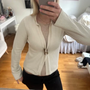 Krämvit kofta med knapp från Gina - Vit kofta från Gina med knäppning längst upp. Superskönt material! 🩷