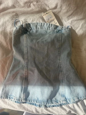 Ljusblå denim korsett topp XS - Trendig ljusblå korsett topp från Zara i denim. Toppen har en dragkedja bak för enkel påklädning och en croppad passform som ger en snygg siluett. Perfekt för att lyfta vilken outfit som helst.