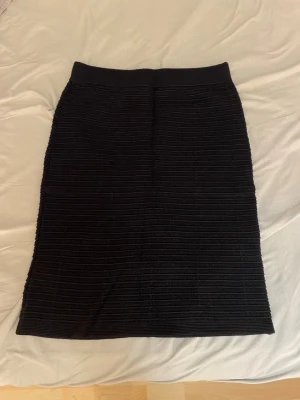 Svart ribbad långkjol från LOFT - Säljer en svart långkjol från LOFT Outlet i storlek XS. Kjolen har ett ribbat mönster och är gjord i ett mjukt, stretchigt material som sitter snyggt på kroppen. Perfekt att styla med en enkel topp eller stickad tröja.