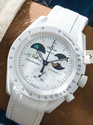 Omega x Swatch Speedmaster Moonswatch - Snygg vit Omega x Swatch Speedmaster Moonswatch med astronaut- och rymdmotiv på urtavlan. Klockan har vit boett och matchande vitt textilband. Detaljer i blått och svart på visarna och urtavlan ger en unik look. Perfekt för dig som gillar coola accessoarer.