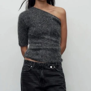 Alpaca oneshoulder tröja - Från zara i strl M och aldrig använd med prislapparna kvar!  Snygg grå oneshoulder tröja med en unik design. Tröjan har en kort ärm och är tillverkad i alpacka material som ger en bekväm passform. Perfekt för att ge en stilren look. 