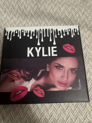 Kylie läppstift set metallic - Snyggt set med fem metallic läppstift från Kylie. Färgerna varierar från vinröd, koppar, guld, brons till rosa, alla med glansig finish. Hylsorna är svarta med gulddetaljer och droppdesign. Perfekt för dig som vill ha flera färgalternativ i sminkväskan.