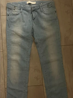 Vintage jeans från Gina Tricot - Snygga ljusblå jeans från GinaTricot med klassisk femficksmodell och raka ben. Jeansen har slitningar och tvättade detaljer framtill för en avslappnad look. Dem har även snygga fick och sidodetaljer! Tillverkade i bomull med en mjuk känsla och normal midja. Perfekta till vardagsstilen.