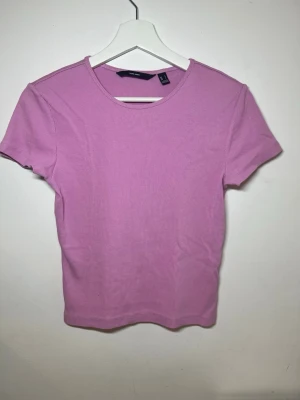 Rosa ribbad t-shirt från H&M - Säljer en söt rosa ribbad t-shirt från H&M. T-shirten har korta ärmar, rund halsringning och är gjord i ett mjukt bomullsmaterial. Perfekt till jeans eller kjol för en enkel och fräsch look.