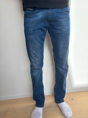 Replay blåa jeans - Säljer ett par blå jeans med rak passform och normal midja. Jeansen har snygga sömmar på bakfickorna. Perfekta till vardags för en avslappnad men stilren look.