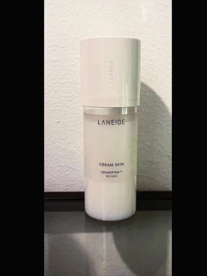 Laneige - Cream Skin Cerapeptide refiner - “The Cream Skin Cerapeptide Refiner is a skin fortifying toner to deeply hydrate and strengthen the skin barrier. Combining the functions of toner and a moisturizer to promote long-lasting hydration with the Cream Blending Technology this cream skin is enriched with white leaf tea water that's rich in amino acids to soothe and strengthen skin's barrier. Also contains Cerapeptide to help improve your skin’s elasticity.” Innehåller från början 170 ml, återstående mängd syns på bilderna.
