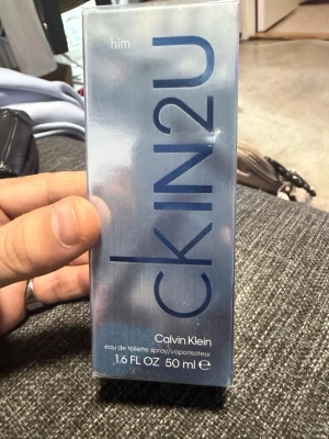 Calvin Klein CK IN2U Him EdT 50ml - Fräsch herrparfym från Calvin Klein, CK IN2U Him, i en stilren silverblå förpackning. Eau de toilette med citrus- och tränoter, perfekt för dig som gillar moderna och energiska dofter. Flaskan rymmer 50 ml och har en minimalistisk design.