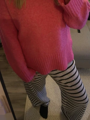 Rosa stickad tröja från Pieces - Mysig rosa stickad tröja från Pieces med rund halsringning och breda ribbade muddar vid ärmslut och nederkant. Tröjan har en avslappnad passform och är perfekt för att hålla värmen under kyliga sommarkvällar🌸