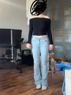 Ljusblå bootcut jeans - Säljer ett par ljusblå bootcut jeans med klassisk femficksdesign och normal midja. Jeansen har en snygg, något utsvängd passform nertill och stängs med dragkedja och knapp. Perfekta för en trendig och avslappnad look.