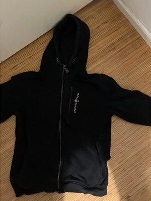 Svart zip kofta från Sail Racing - Svart zip med dragkedja från Sail Racing. Storlek 160 skulle säga 154 till 158 kan ha den också fraktar varan samma dag 