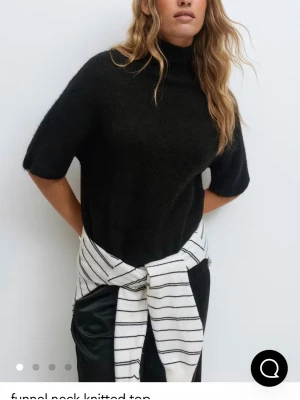 Svart stickad topp från Gina - En svart stickad topp med funnel neck och korta ärmar. Storlek XS från Gina😇 Helt slutsåld på hemsidan🤗🤗