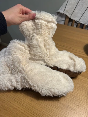 Warmies supa mjuka tofflor - Warmies Höga Tofflor Deluxe. Oanvända. Köpt. På Apohem för 399 kr. Det är mjuka tofflor som är fyllda med naturliga hirskorn och lavendel (så de doftar lavendel). De höga tofflorna värms enkelt upp i mikrovågsugnen och ger en behaglig, långvarig värme. Tillverkade i ett supermjukt plyschmaterial.  Storlek: Passar skostorlek 37–42.