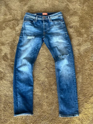 Blå slitna jeans från Jack & Jones - Tjenare, däljer nu ett par feta jack and jones jeans som sitter w28  l30. Jeansen är knappt använda och är i strålande sick. Skeiv om ni har några frågor så är jag glad att kunna få svara på dom🤝🙌