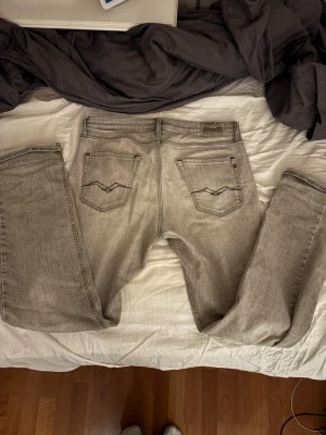 Grå Replay jeans - Säljer ett par ljusgrå jeans från Replay med klassisk femficksmodell och raka ben. Jeansen är i storlek W29 L30. Det är en lite sällsyntare modell som heter Thad. Tycker dem är skit feta men lite för små för mig så har inte använts 