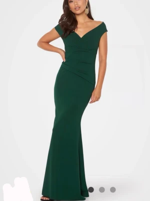 Mörkgrön långklänning med v-ringning - Stilren smaragdgrön långklänning med v-ringad hals och smala axelband. Klänningen har en slim passform som framhäver figuren och ett elegant fall, perfekt för bal. Jag är 158 med klackar är de fortfarande lite lång men går att vicka upp eller sy upp. Pris kan diskuteras 