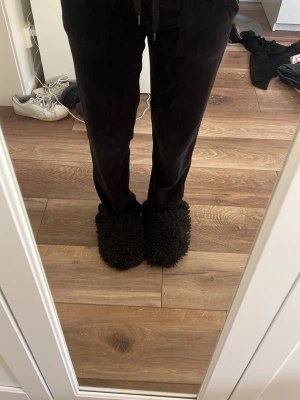 Svarta mjukisbyxor med raka ben - Ett par svarta mjukisbyxor i mjukt material med raka ben och dragsko i midjan. Byxorna har fickor både fram och bak samt en enkel, clean look. Perfekta för chill dagar när du vill vara bekväm men ändå se fräsch ut.