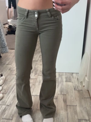 Gröna lågmidjade jeans - Jag säljer ett par gröna lågmidjade jeans ifrån Nelly, i storlek 32! Använd några få gånger