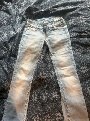 Ljusblå utsvängda jeans med broderad detalj - Säljer ett par ljusblå jeans med utsvängda ben som är LÅGMIDJADE, som ni ser så har ja sprättat upp benen där nere. Dom passar mig som är 167 väldigt bra, men tänk på att dom är väldigt lågmidjade bara. Super fina jeans och lätta att styla. Skriv för frågor eller bilder💕