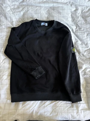 Svart Stone Island sweatshirt - Svart Stone Island sweatshirt/tjocktröja står L men passar BARA S liten chans det funkar på M, väldigt skön och snygg passar fint till allt!