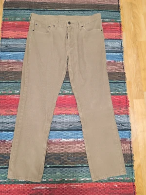 Levi's 511 beiga manchester byxor, storlek W36 L30 - Säljer ett par klassiska beiga manchesterbyxor från Levi's med raka ben och femficksmodell. Byxorna har en snygg vintage-look och är tillverkade i mjuk manchester. Perfekta för dig som gillar avslappnad stil och tidlös design. Knappt använda.