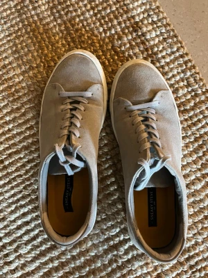 Gråa sneakers från Sneaky Steve - Snygga gråa sneakers från Sneaky Steve i mocka och med märkeslogga på hälen och insidan. Använda ett par gånger. Storlek 43