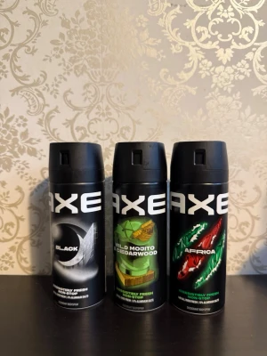 Axe deodorant body spray 3-pack - Tre olika Axe deodorant body sprays: Black, Wild Mojito & Cedarwood samt Africa. Alla har svart cylinderformad flaska med färgglada detaljer och stor vit logga. Perfekt för dig som vill ha fräscha och unika dofter i vardagen.