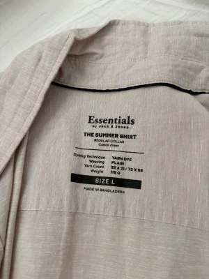 Ljusbeige linneskjorta Essentials L - Snygg ljusbeige skjorta från Essentials by Jack & Jones i storlek L. Skjortan är tillverkad i en mix av bomull och linne, har korta ärmar, klassisk krage och knäppning framtill. Perfekt för varma dagar och enkel att styla.