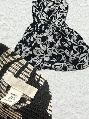 Svartvit blommig klänning H&M - Snygg svart klänning från H&M med vitt blommönster. Klänningen är kort och har en markerad midja samt ärmlös design. Tillverkad i bomull, perfekt för varmare dagar och ger en fräsch look.
