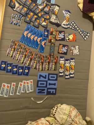 Stort paket med klistermärken - Säljer ett stort paket med olika klistermärken i flera färger och motiv, bland annat tecknade figurer, logotyper och text. Perfekt för att dekorera laptop, mobil, cykel eller skolgrejer. Blandade former och storlekar, mestadels i blått, vitt och rött.