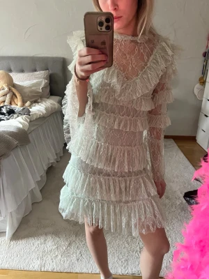 Mintgrön By Malina klänning - Superfin mingrön By Malina klänning med flera lager volanger och spetsdetaljer. Klänningen har långärmade ärmar och hög hals, vilket ger en elegant look. Perfekt inför kommande student eller studentfester!! Klänning har använts få gånger, så är i väldigt fint skick. Hör av dig vid frågor!💕💕