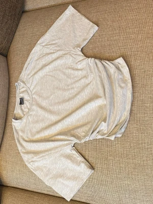 Ljusgrå t-shirt - En enkel och stilren ljusgrå t-shirt från Gina Tricot med rund hals och korta ärmar. Perfekt till jeans eller shorts. Utan prislapp men aldrig använd.