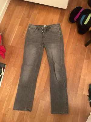 Grå raka jeans från 157 - Säljer ett par grå jeans från 157 med rak passform och klassisk femficksdesign. Jeansen har en snygg tvättad look och är tillverkade i ett slitstarkt denimtyg. Perfekta för dig som gillar en enkel och stilren stil.